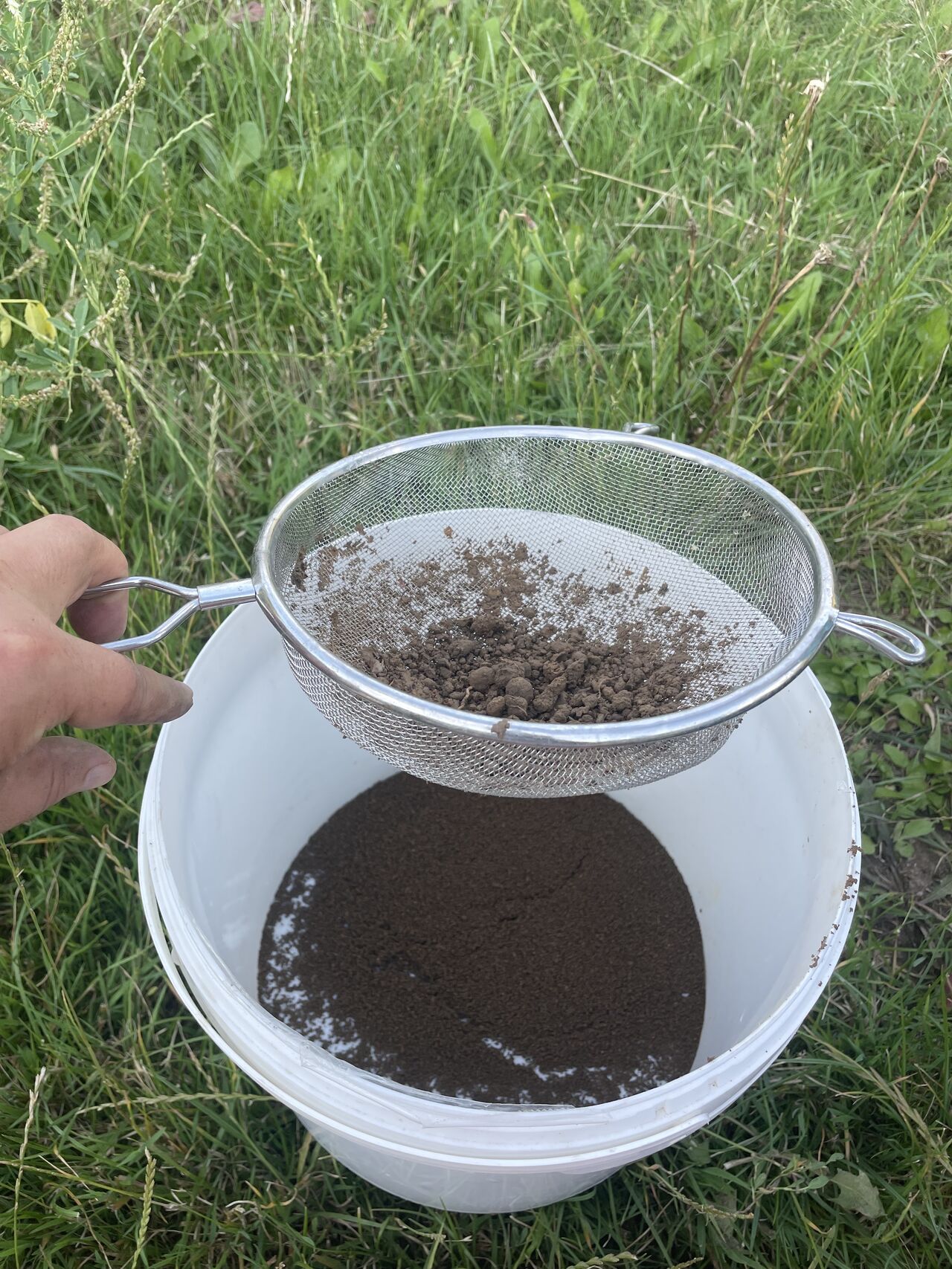 Przesiewanie gleby przez grube sito